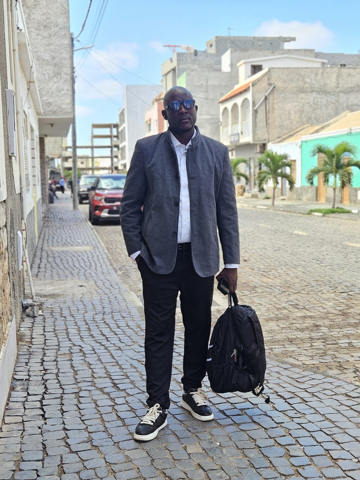 Austin Obule Emovworho in a tailored suit on a street in Cape Verde