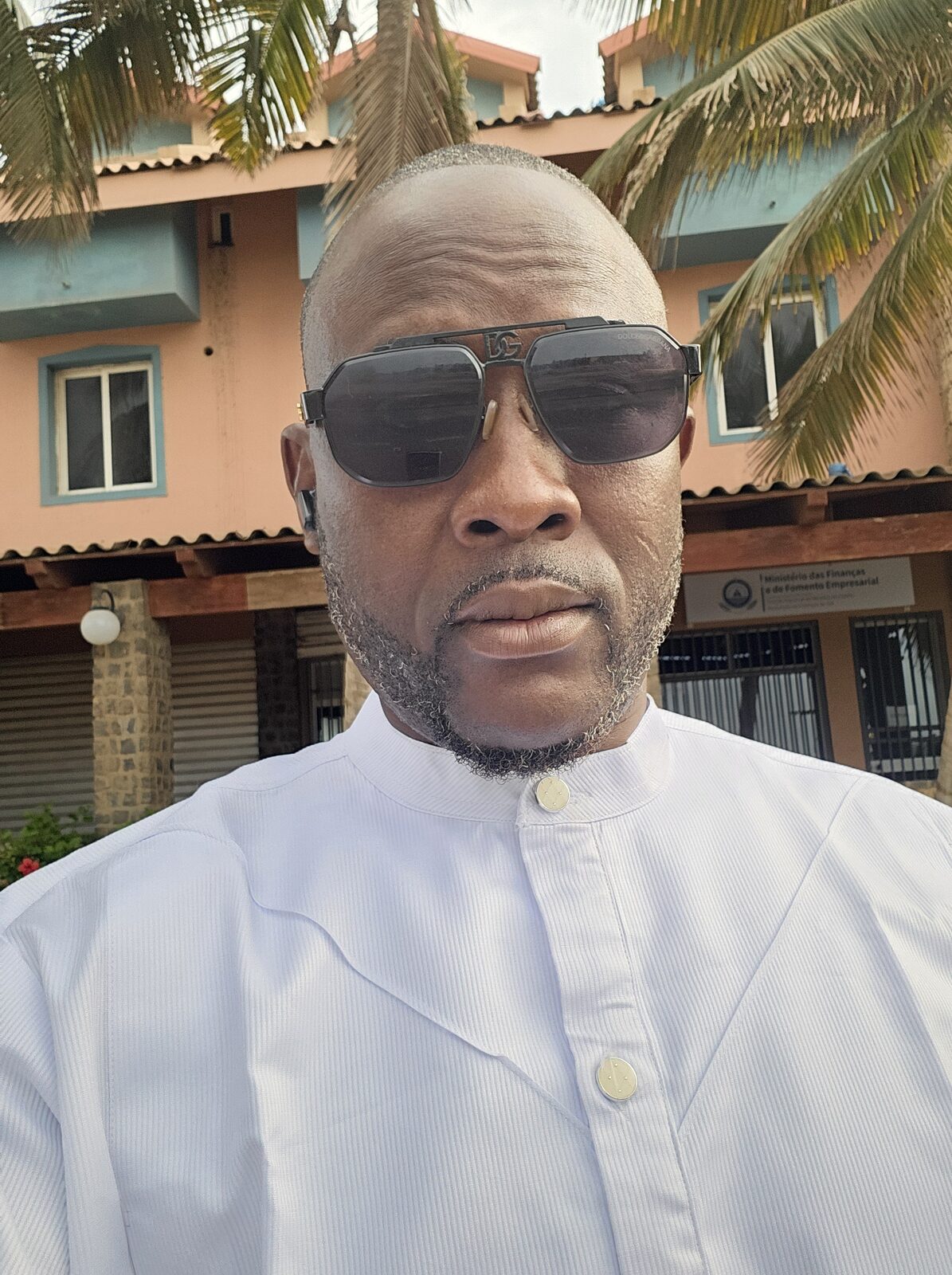 Austin Obule Emovworho in white attire amid palm trees in Cape Verde