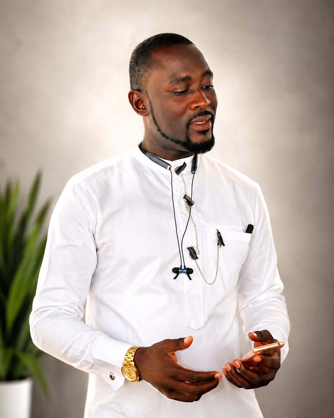 Austin Obule Emovworho speaking at an event wearing a crisp white outfit with a lapel microphone