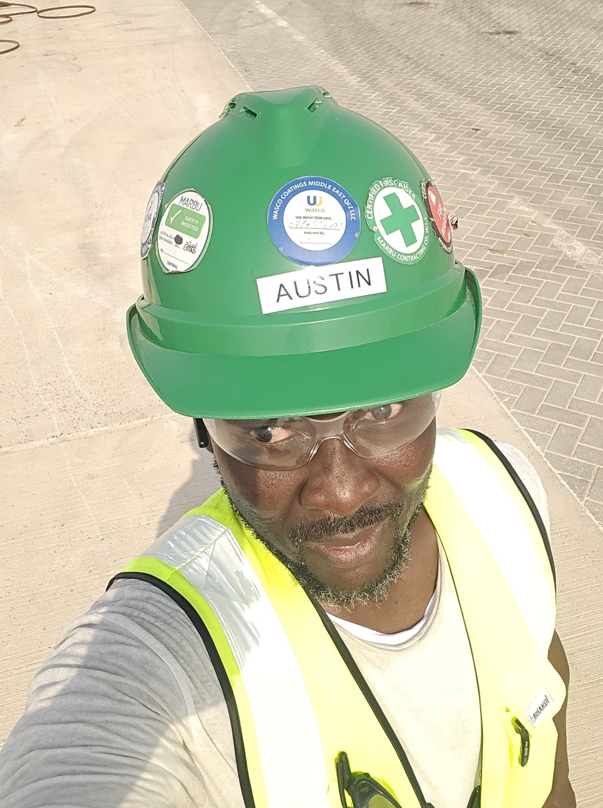 Austin smiling on site wearing a certified HSE helmet and safety eyewear