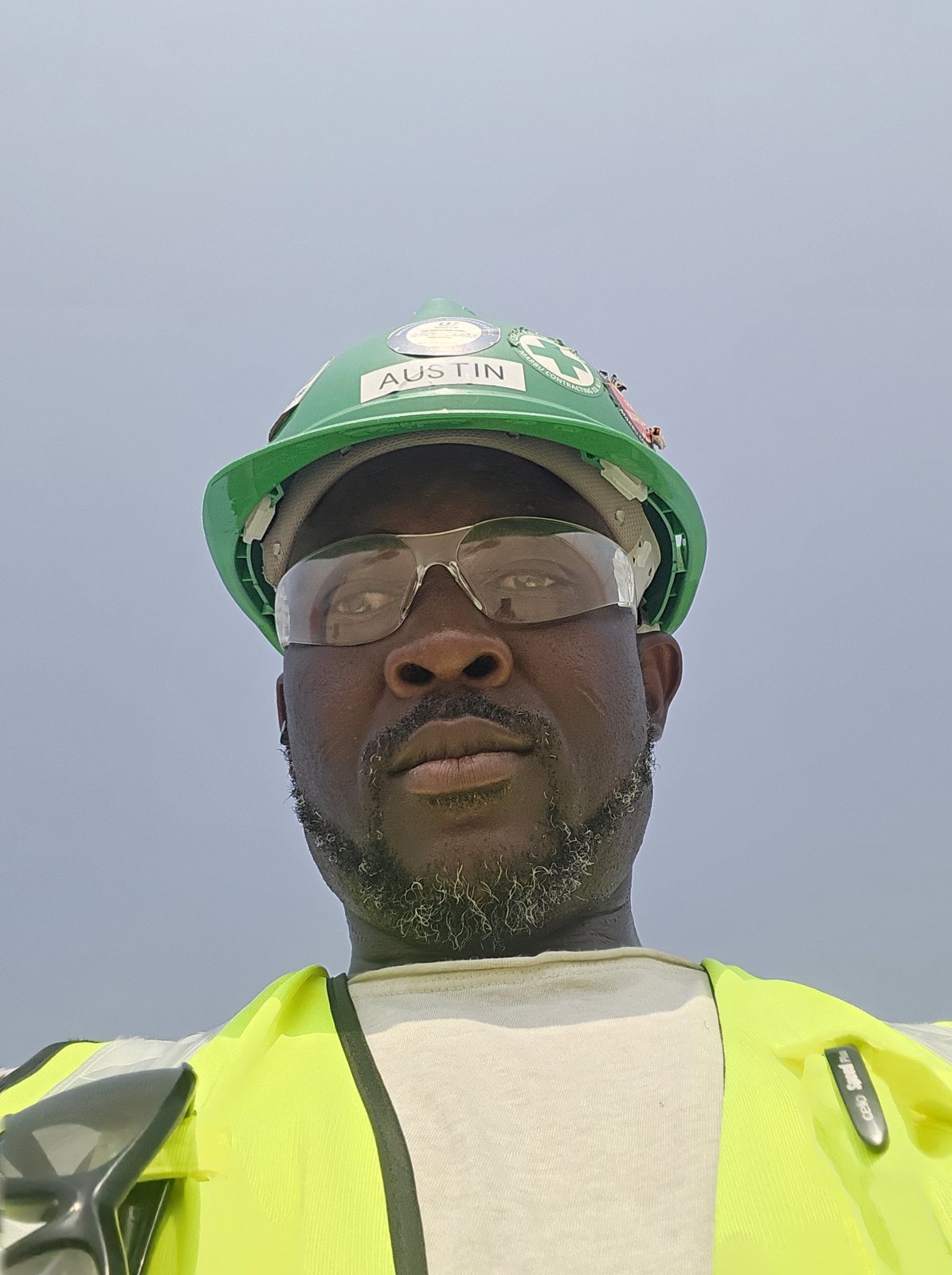 Austin Obule Emovworho in branded HSE helmet and hi-vis vest on a Qatar waterfront project site